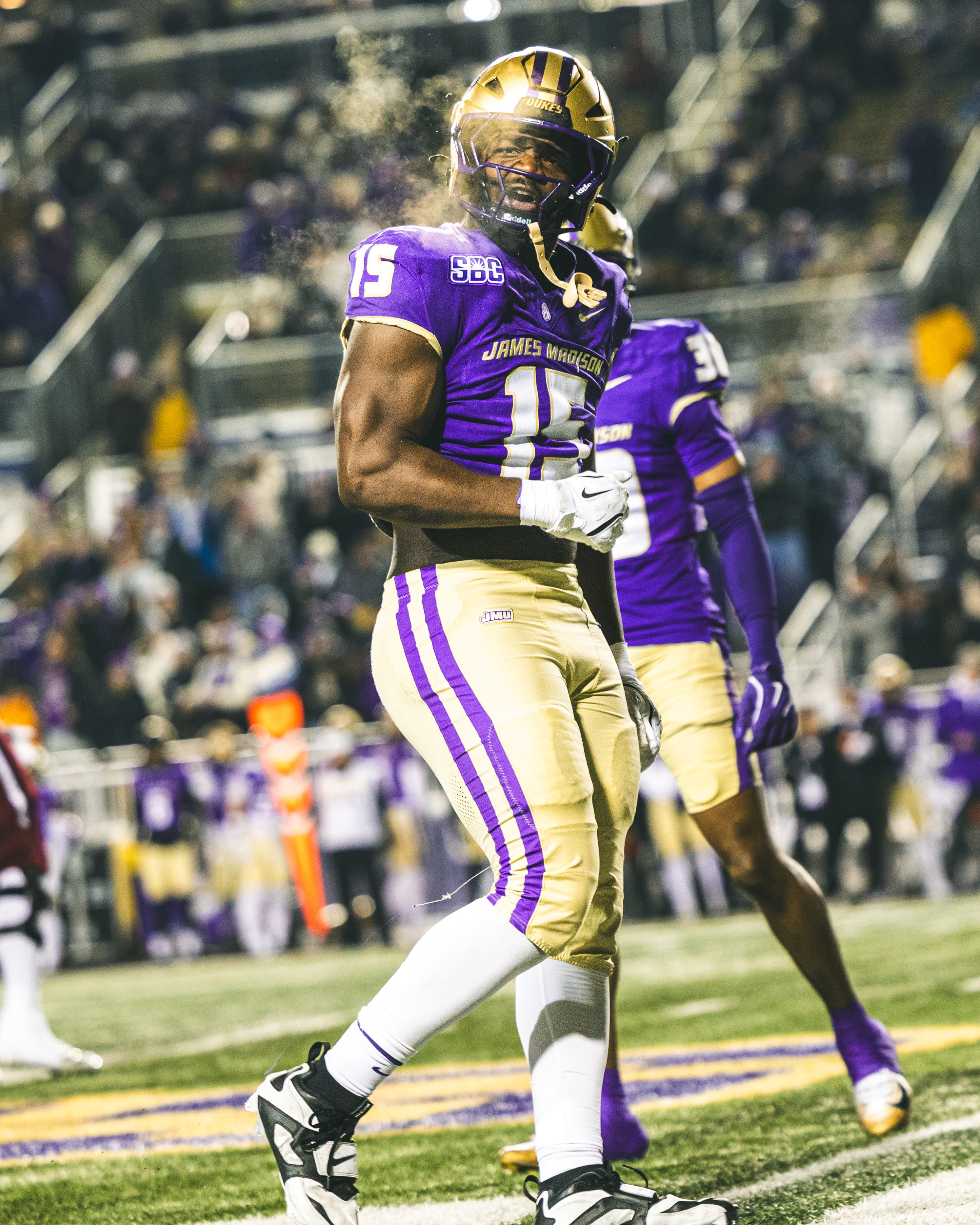 JMU football player exhaling vapor during a night game